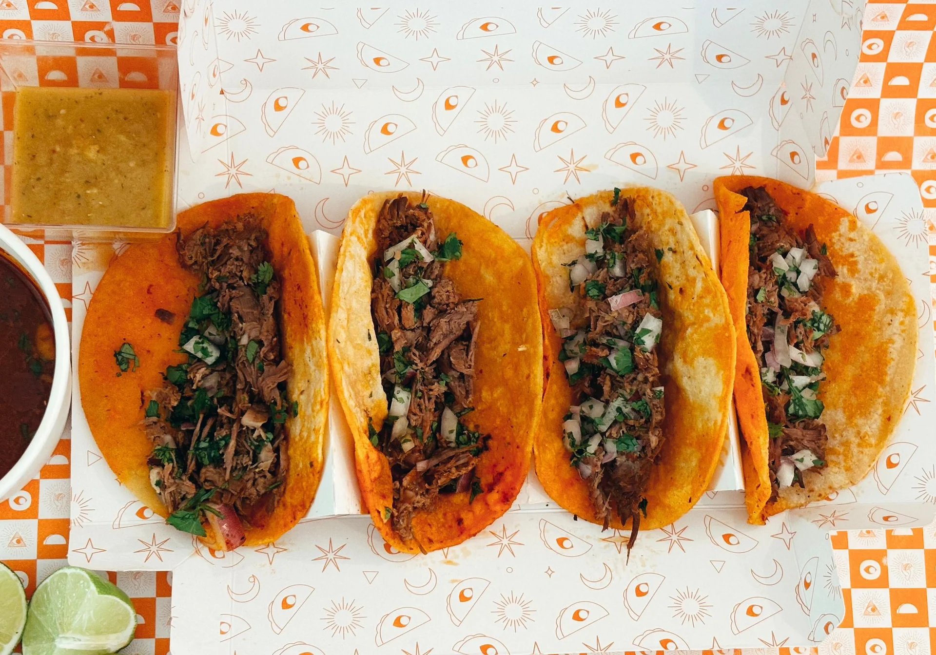 Juicy birria tacos being dipped in consommé